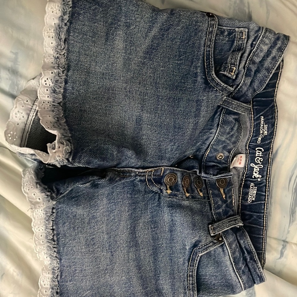 Washed blue cat & Jack shorts with white fringe at the bottom. Size 7/8